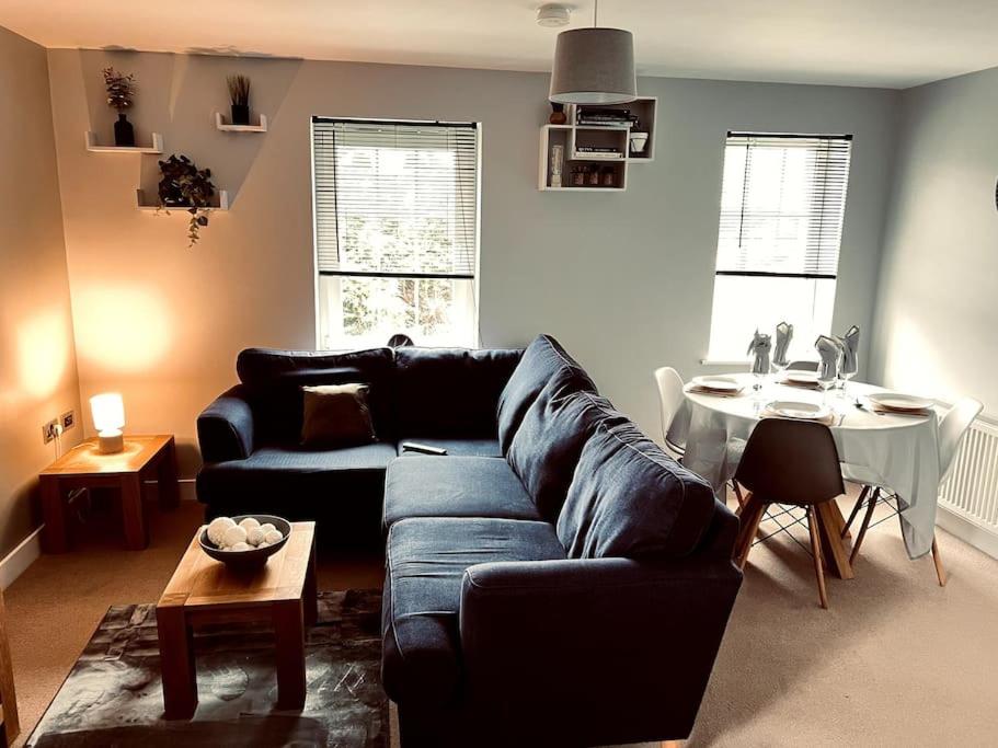 uma sala de estar com um sofá azul e uma mesa em Lakeland Living - Devenish Manor em Enniskillen