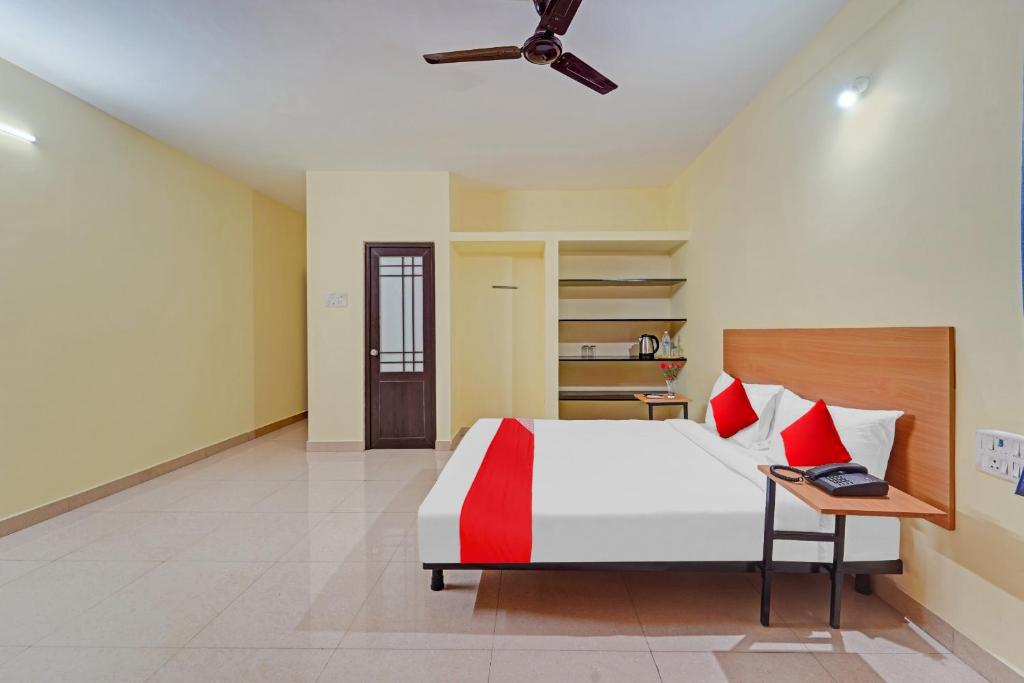 um quarto com uma cama e uma mesa com um computador portátil em Flagship Maxworth em Chennai