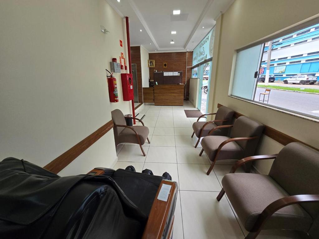 una sala d'attesa con sedie e un corridoio di Pousada Santa Gianna a Aparecida
