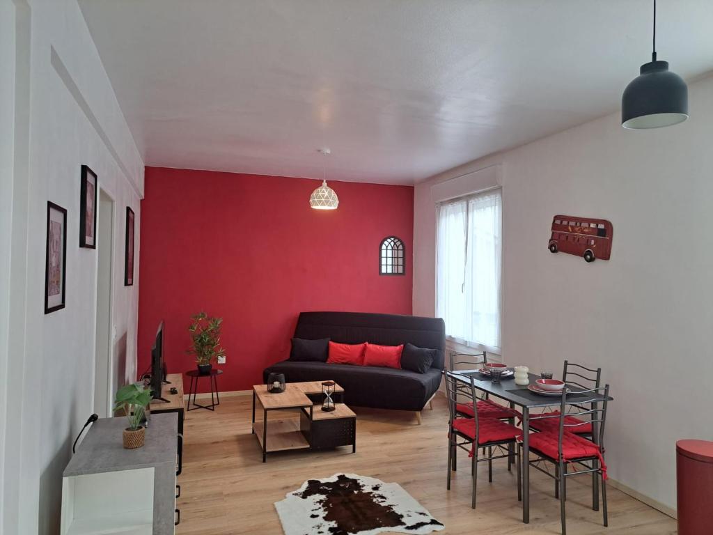 a living room with a black couch and a table at Confortable Apart de 3 pièces in Poitiers
