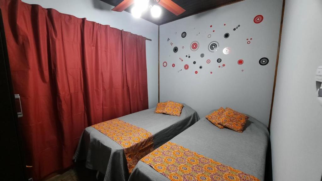 a bedroom with two twin beds and a wall with clocks at Brisas de Killa in General Rodríguez