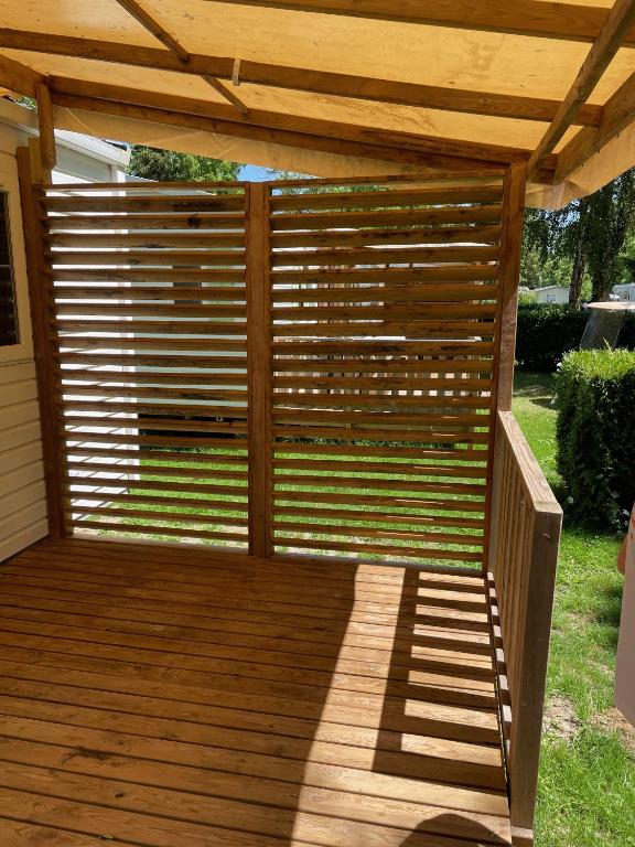 a wooden deck with a wooden pergola at Bungalow pour 5 - TV - Clim - Terrasse ensoleillée in Boofzheim