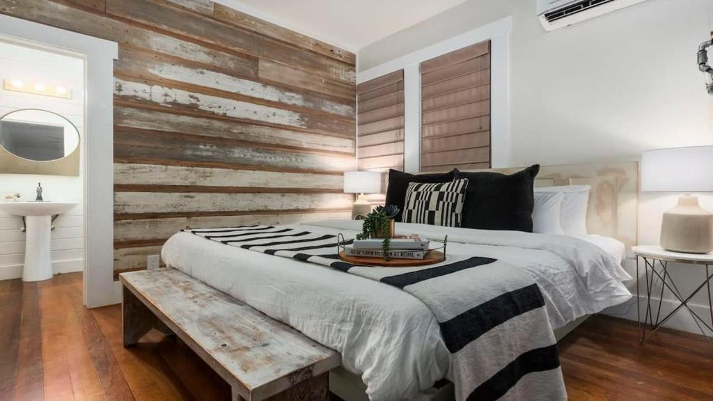 a bedroom with a large bed and a wooden wall at The Downtown Studio 2 private hot tub in Fredericksburg