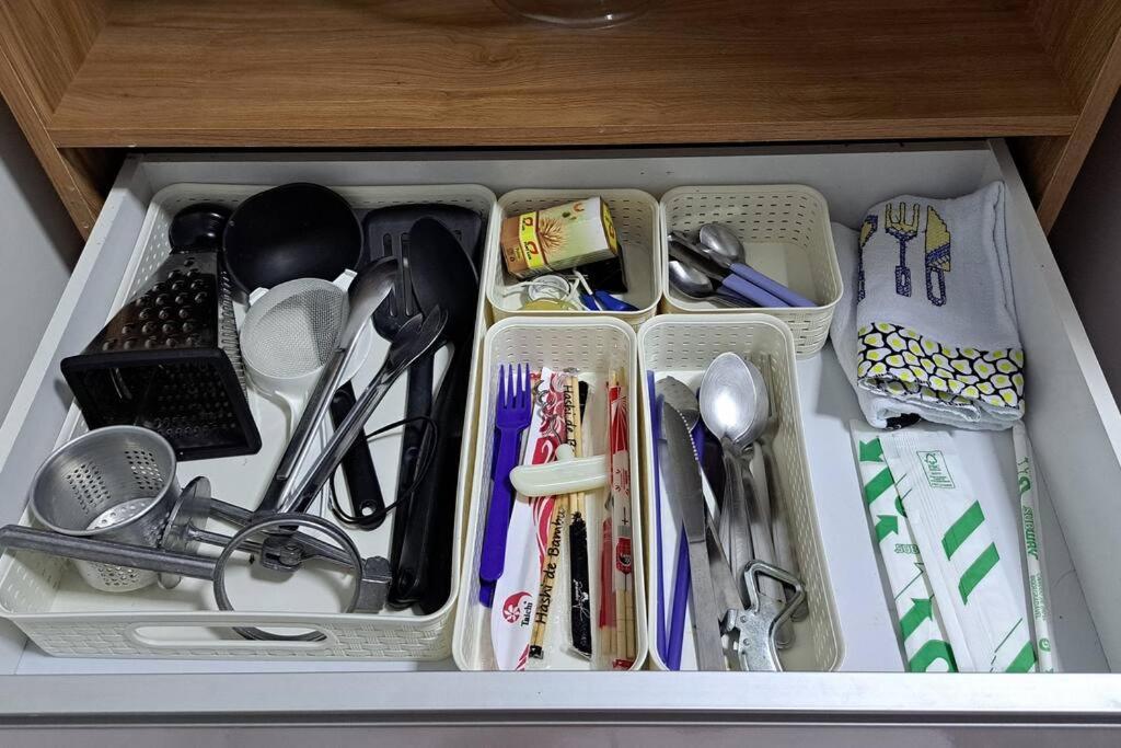 a drawer filled with utensils and other kitchen items at Apto inteiro - WiFi, ar condicionado, Piscina in Cuiabá