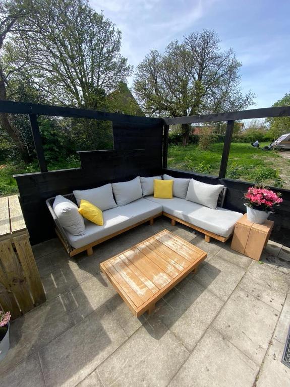 a couch and a coffee table on a patio at Ecolodges De Dreef Guesthouse in Renesse