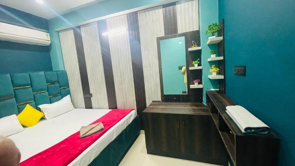 a small room with a bed and a mirror at HOTEL DBR in Muzaffarpur