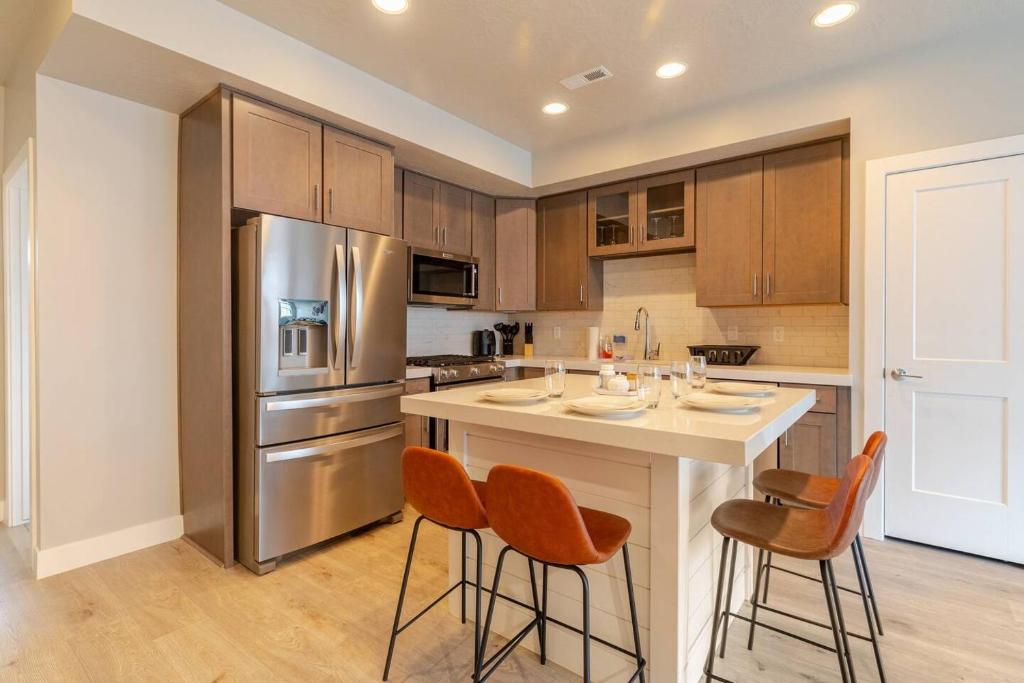 una cocina con una gran isla con taburetes de bar en Park City Modern New Park City Townhome en Park City