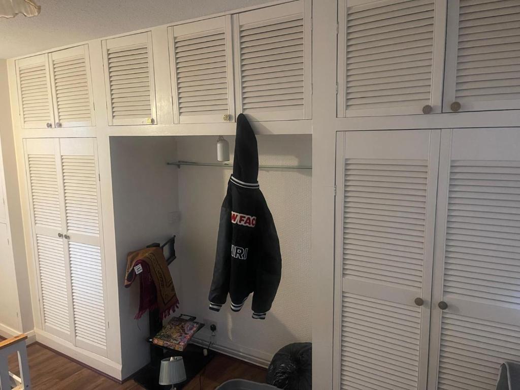 a closet with a sweatshirt hanging on the wall at Tarar’s house in Streatham Hill