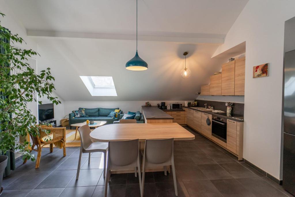 cocina y sala de estar con mesa de madera y sillas en La Champanaise - 2 bedroom apartment 300m from Lake Annecy, en Duingt