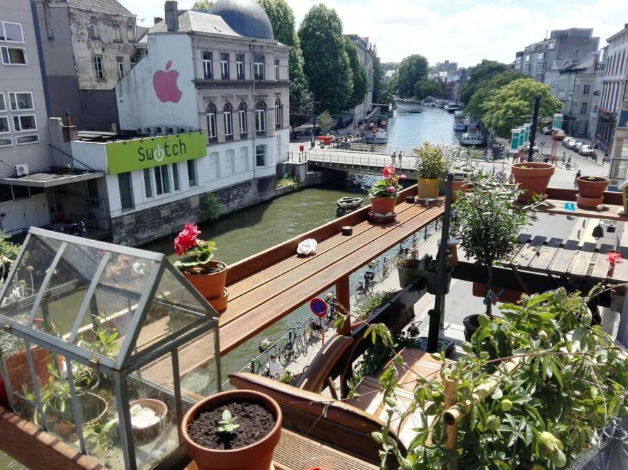 a balcony with potted plants and a view of a river at Breathtaking Views in heart of Ghent in Ghent