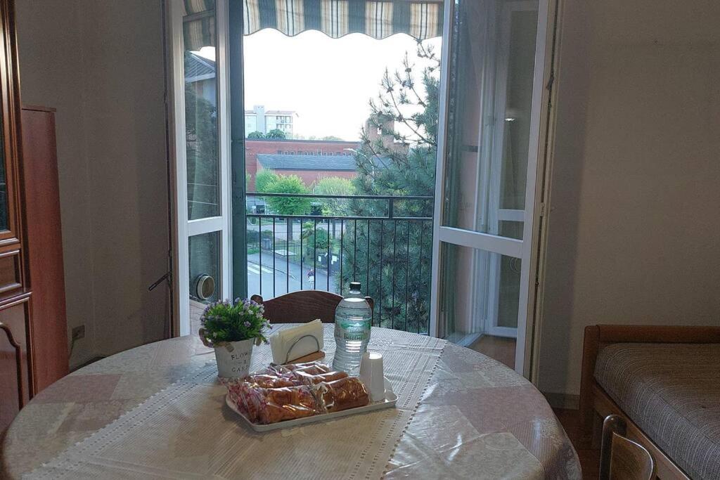 a table with a plate of food and a window at IRIS Bilocale Sant'Anna in Busto Arsizio