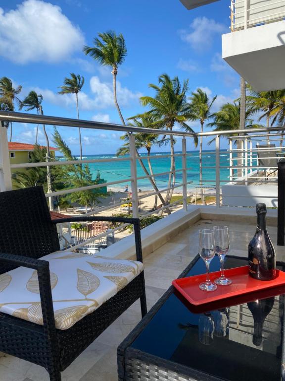 einen Balkon mit Tisch und 2 Weingläsern in der Unterkunft Apartamento en la playa. in Punta Cana