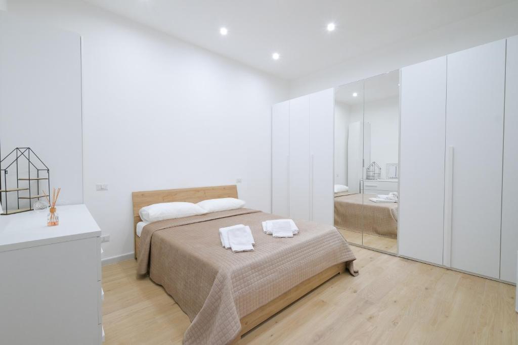 a white bedroom with a bed and a bathroom at Antonia’s House in Bari