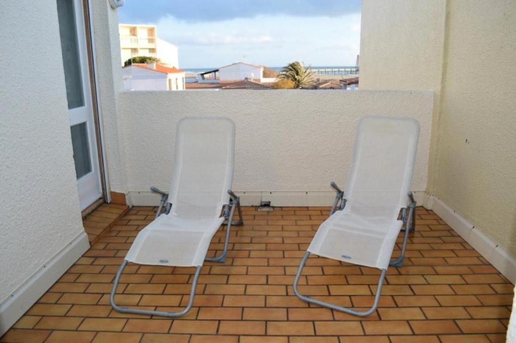 - deux chaises sur un balcon avec vue sur l'océan dans l'établissement Résidence Le Soulairol - 3 Pièces pour 5 Personnes 24, à Port-Leucate