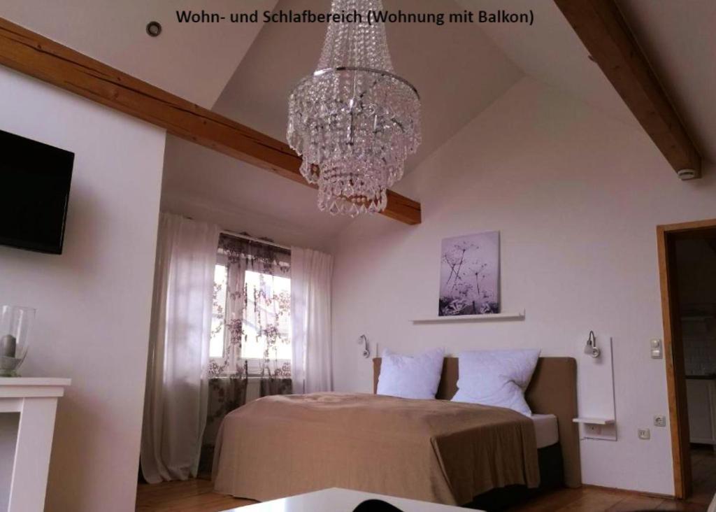 a bedroom with a chandelier and a bed at Ferienwohnungen zentral Altötting in Altötting