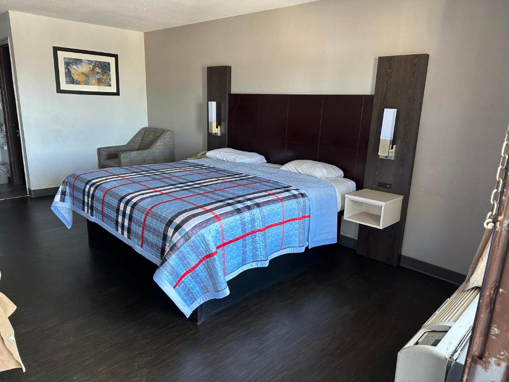 een hotelkamer met een bed en een stoel bij Scottish Inn Augusta downtown in Augusta