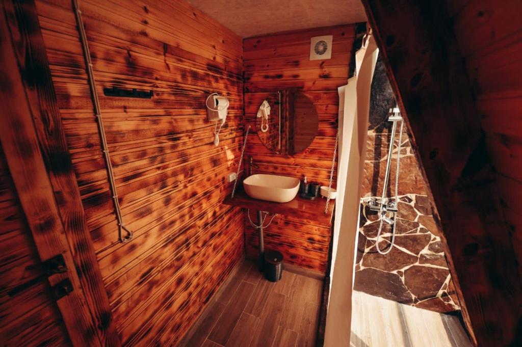 a bathroom in a log cabin with a sink at The overlook cottage in Batumi