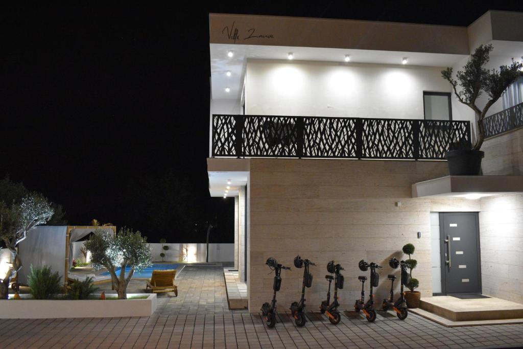 a building with a row of scooters on the side at Villa Lauvi, Free Fiat 500 Cabriolet, Scooters , PS5 in Kaštela