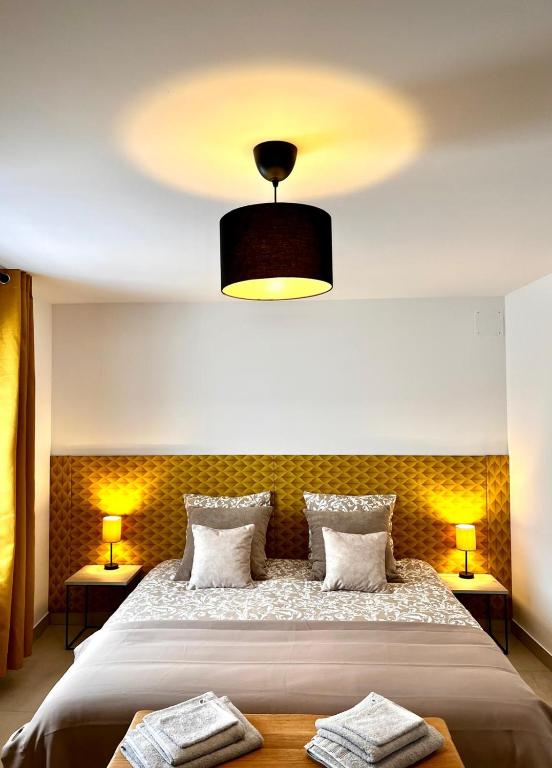 une chambre avec un grand lit avec deux lampes dans l'établissement La Maison du Cocher, à Étival-Clairefontaine