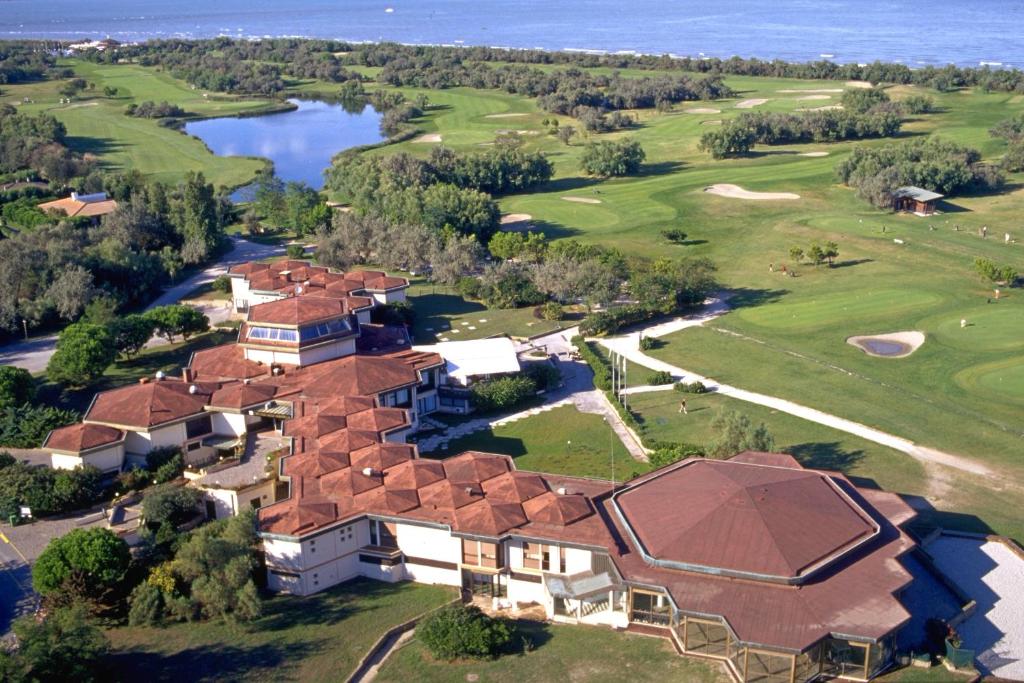 - une vue aérienne sur une maison avec un parcours de golf dans l'établissement Isola di Albarella Golf Hotel, à Albarella