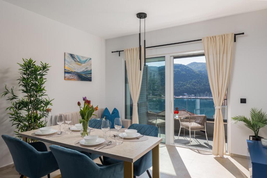 a dining room with a table and chairs and a large window at Luxury Apartments Blue Moon - New Apartments in Slano
