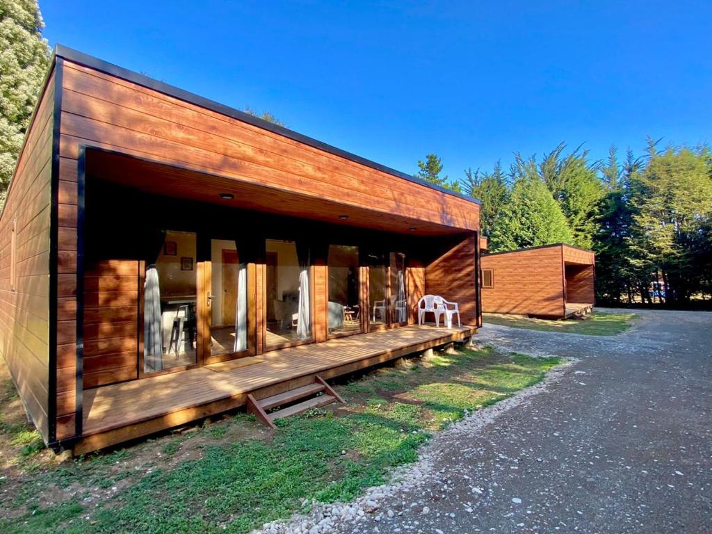 ein Holzgebäude mit einer großen Fenstergruppe in der Unterkunft Cabañas Los Abetos in Puerto Varas