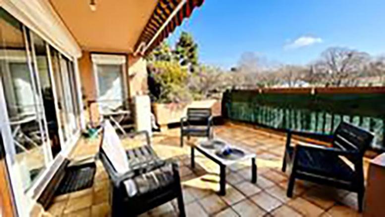 eine Terrasse mit Stühlen und Tischen auf einem Haus in der Unterkunft Logement spacieux avec terrasse in Aix-en-Provence