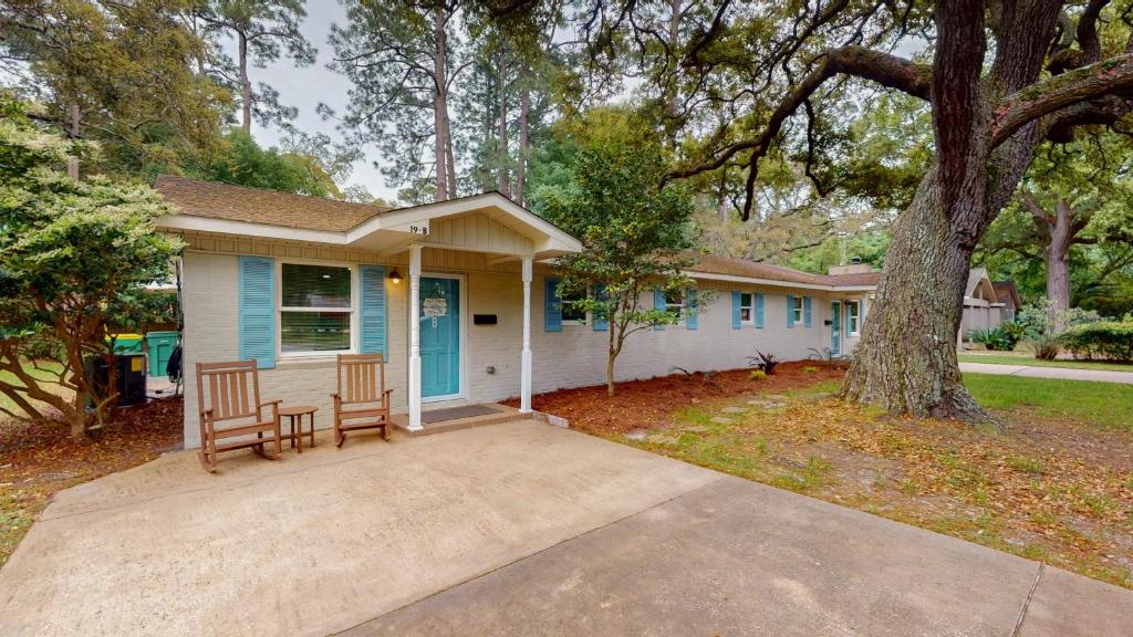 a house with a porch and a tree at BEACHY SISTERS B Duplex in Jekyll Island