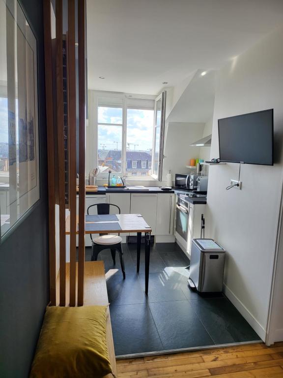 une cuisine avec une table et une cuisine avec une fenêtre dans l'établissement Hyper centre de NANTES, dernier étage vue exceptionnelle, à Nantes