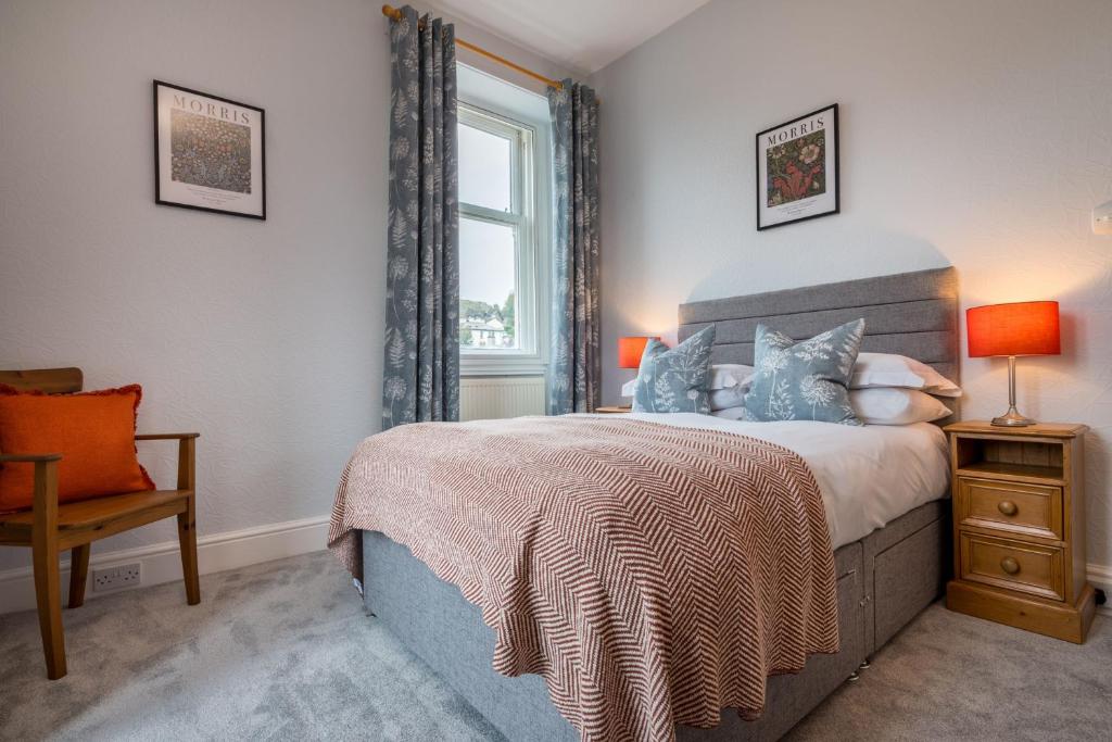 een slaapkamer met een bed, een raam en een stoel bij Wansfell Heights in Ambleside