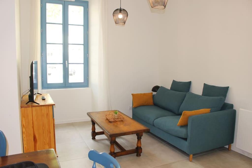 a living room with a blue couch and a table at La terrasse du JULES in Romans-sur-Isère