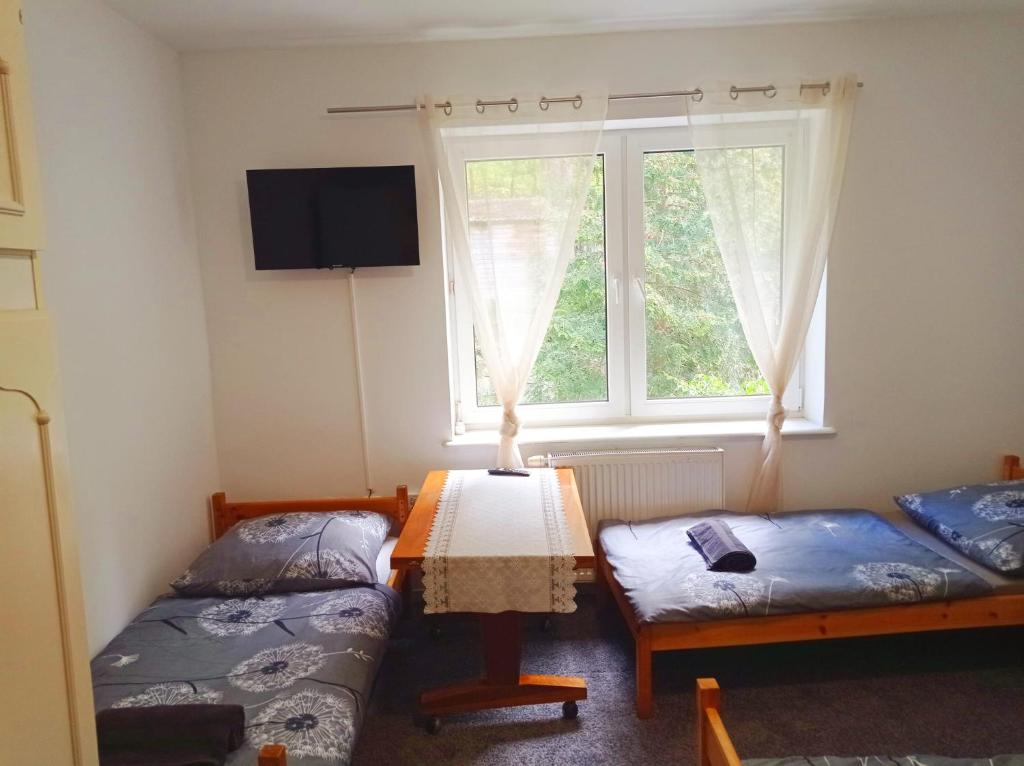 a room with two twin beds and a window at Gdańsk tanie noclegi pokój nr 7 1-4 osobowy z łazienką na korytarzu in Gdańsk