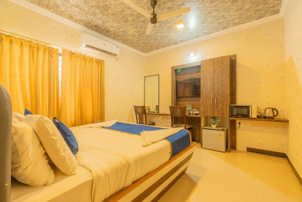 a bedroom with a large bed and a table at Seasons Suites JP Nagar in Bangalore