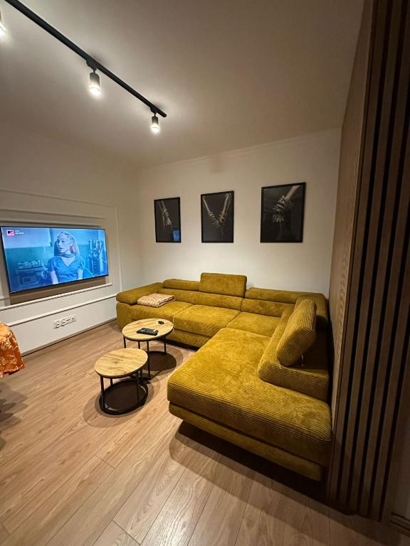 a living room with a couch and a flat screen tv at Celine Apartments in Lębork