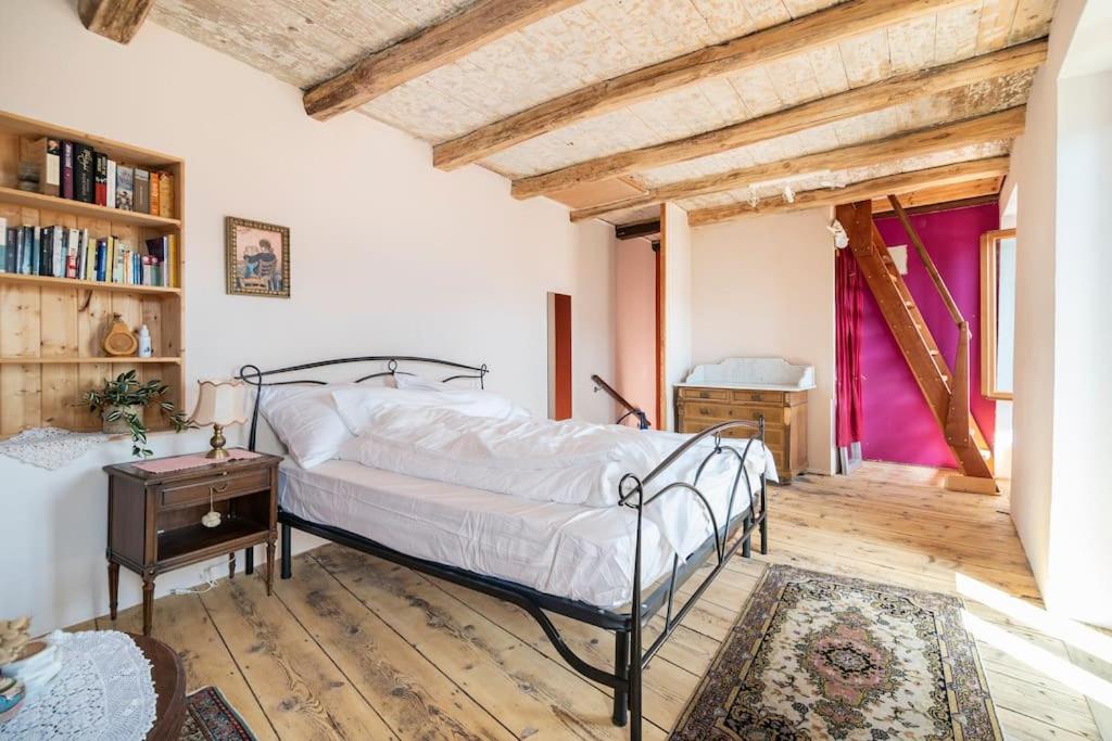 a bedroom with a bed and a wooden floor at Come Relax and Enjoy the Breathtaking Views in Brissago