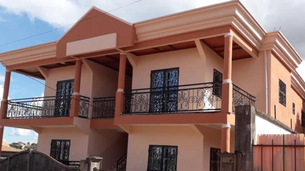 a large house with a balcony in front of it at Nicole Residence in Yaoundé