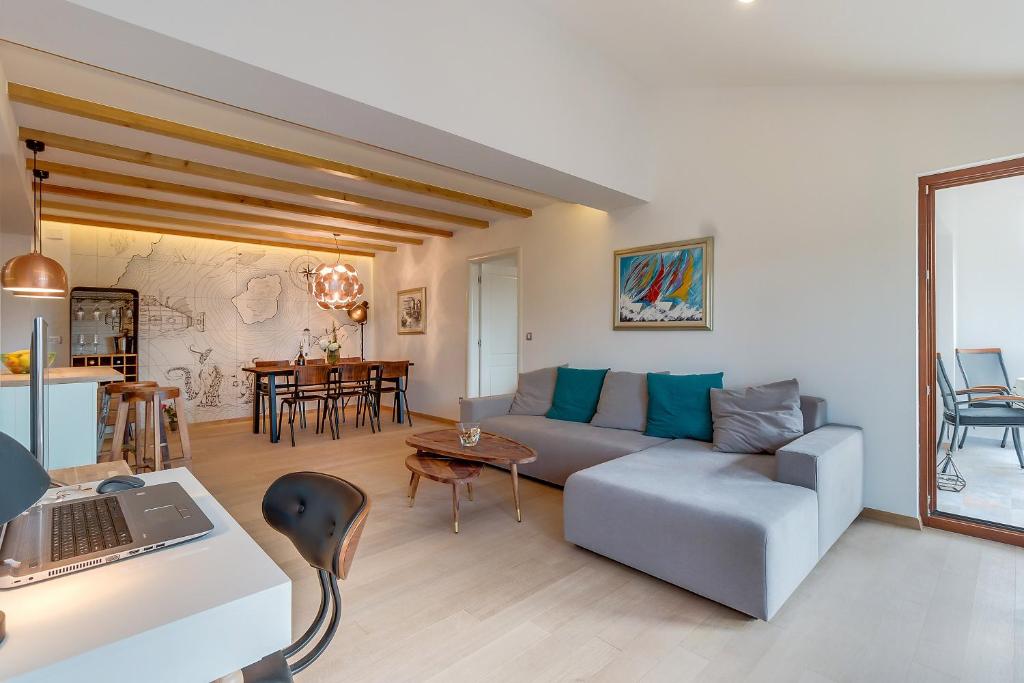 a living room with a couch and a table with a laptop at Villa Lavanda - Kandija in Čunski