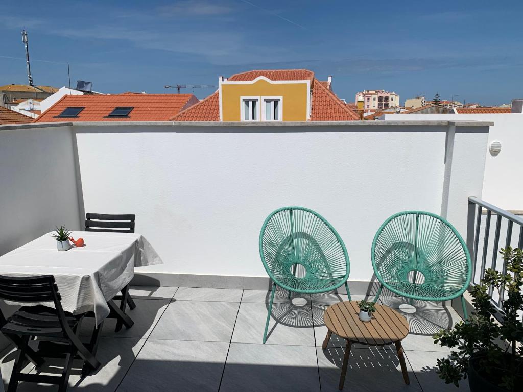 een patio met een tafel en stoelen op een dak bij Peniche36 in Peniche