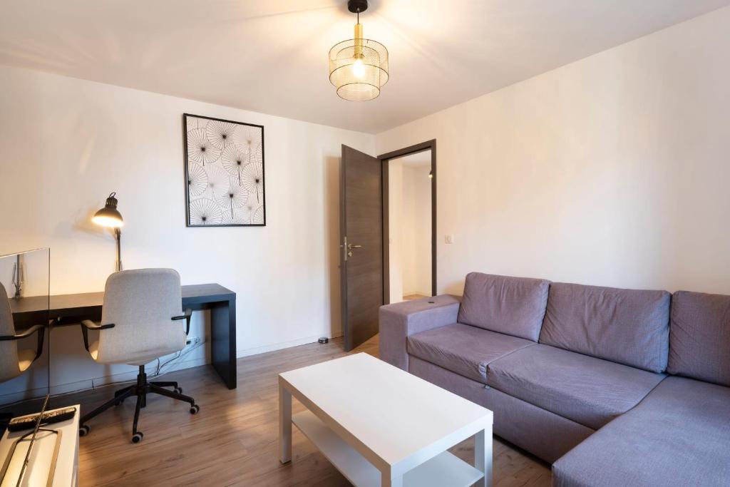 un salon avec un canapé et un bureau dans l'établissement Le cosmopolitain, à Metz