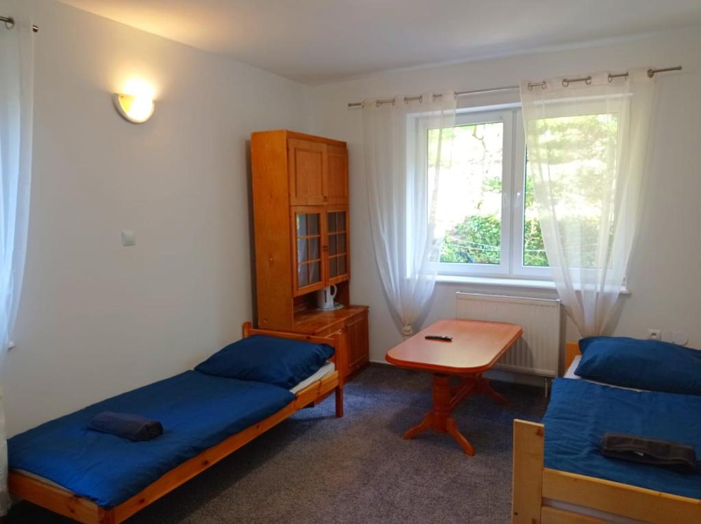 1 dormitorio con 2 camas, mesa y ventana en Gdańsk tanie noclegi pokój nr 2 1-3 osobowy z łazienką na korytarzu, en Gdansk