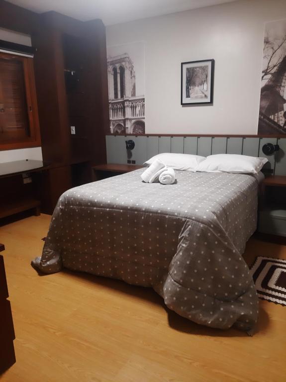 a bedroom with a bed with a polka dot blanket at Solar das Esmeraldas - Apto 105 in Gramado