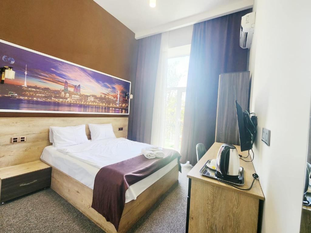 a hotel room with a bed and a television at ELYSIUM HOTEL in Baku