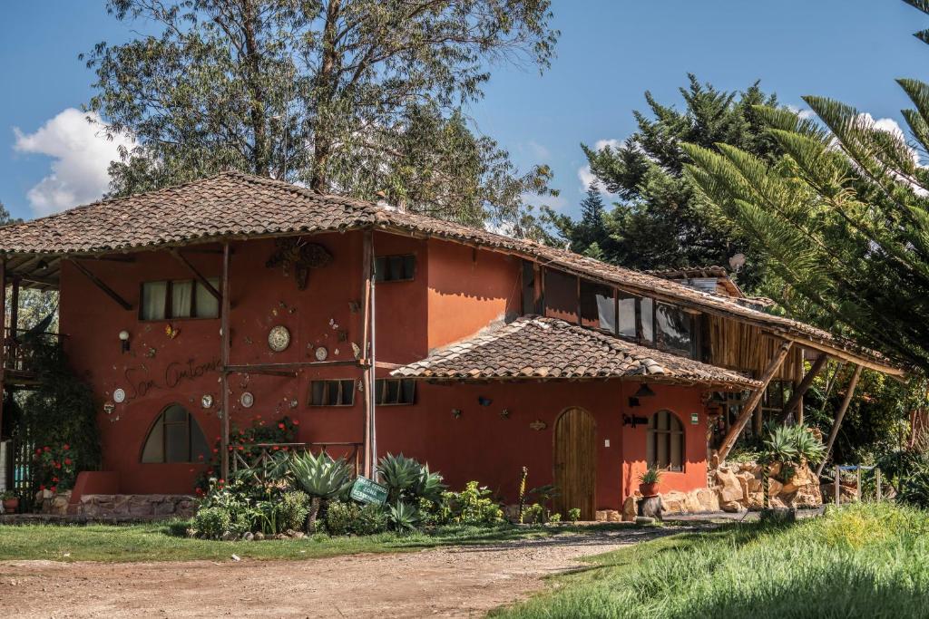 una casa roja con una palmera en ART HOUSE Hacienda San Antonio, en Cajamarca