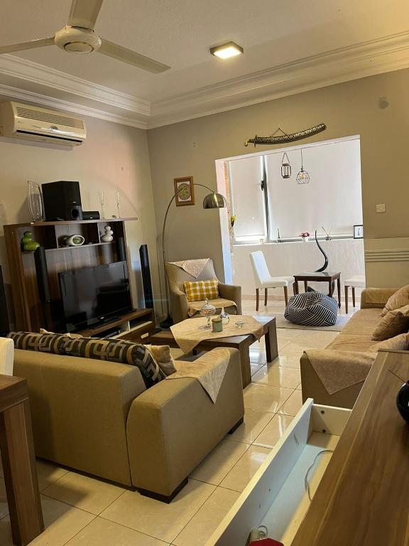 Masa Aqaba Apartment في العقبة: غرفة معيشة مع أريكة وطاولة