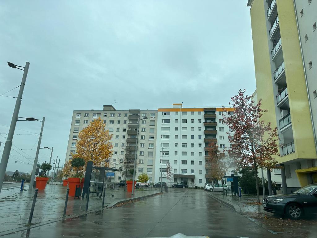 a large white building on a rainy city street at Magnifique studio avec Netflix in Saint-Louis