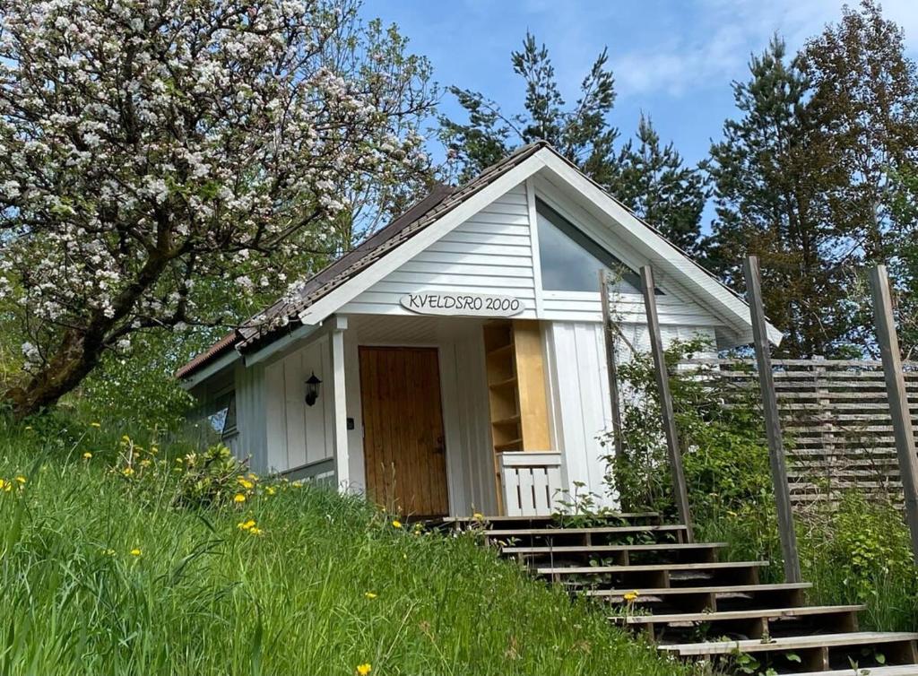 una pequeña casa en una colina con escaleras y árboles en Kveldsro cabin in nice surroundings, en Kristiansand