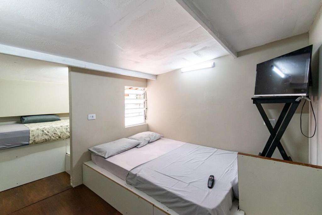 a small room with a bed and a television at 52 LOFT quadruplo · LOFT perto da São Paulo EXPO edo metrô Jabaguara in São Paulo