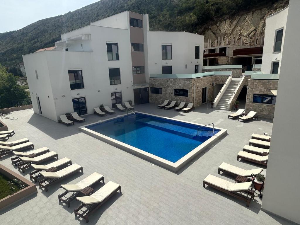 a swimming pool with lounge chairs and a building at WolfMoon in Herceg-Novi