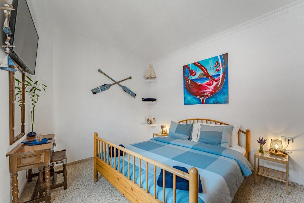 a bedroom with a blue bed and a tv at Atico Garamar in Garachico