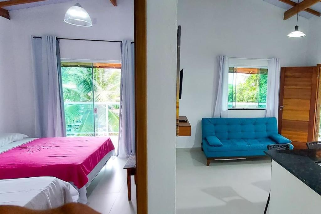 um quarto com uma cama azul e um sofá azul em Chalés João&Maria - Ilhabela em Ilhabela